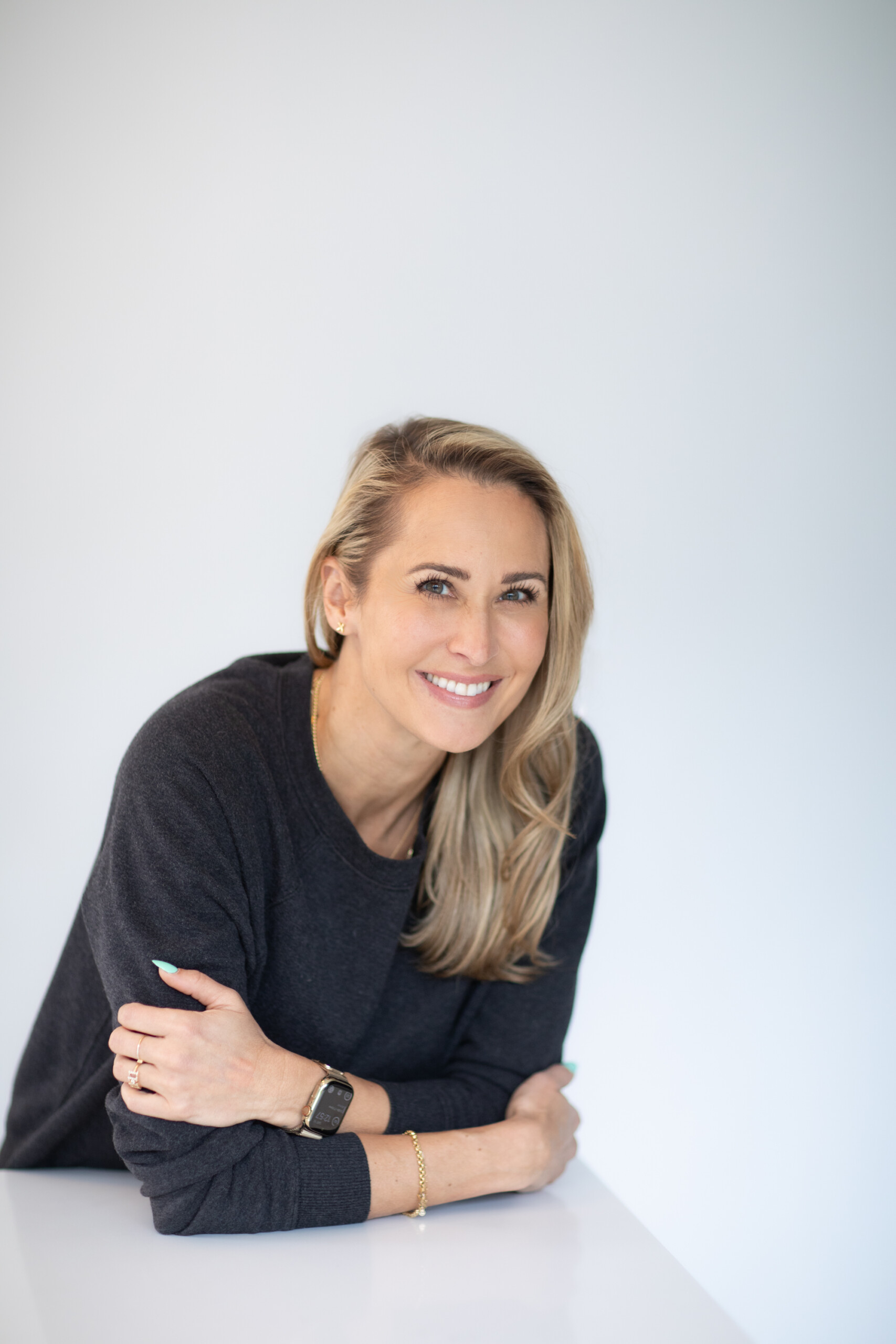 Kristen Gale smiling at a desk, representing the identity shift and personal growth that comes with starting a new business.
